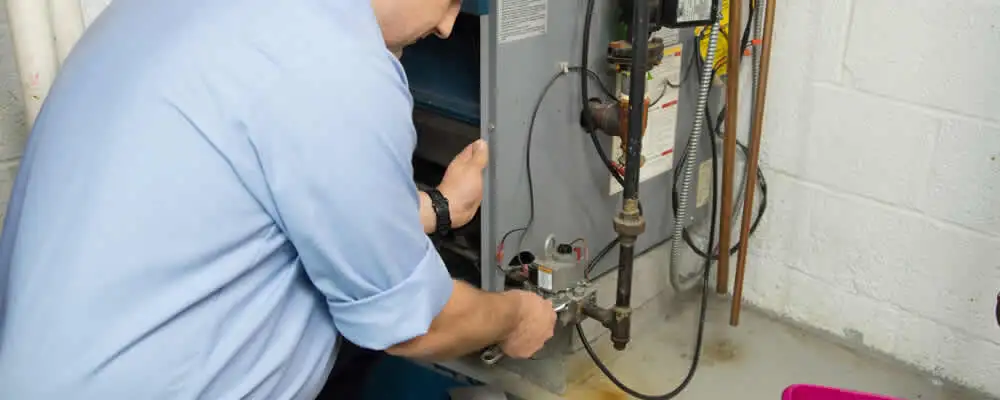 Furnace repair technician inspecting and servicing a home heating system in Sacramento, CA