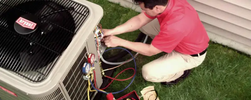 HVAC technician servicing an outdoor air conditioner unit in Sacramento, CA