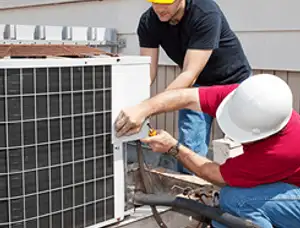 HVAC technicians repairing an outdoor AC unit on a rooftop in Sacramento, CA