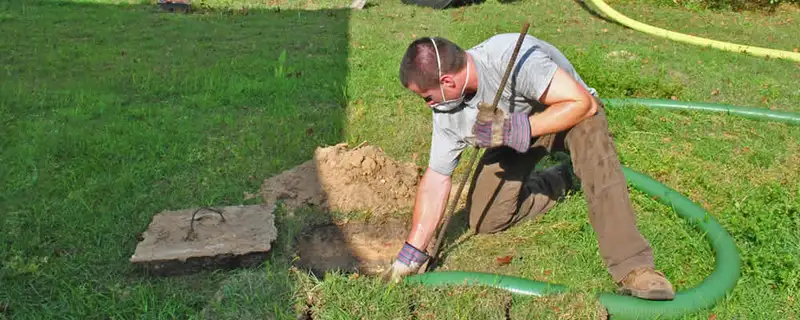 Septic pumping technician servicing a residential septic tank in Sacramento, CA