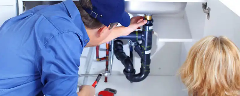 Plumber repairing under-sink drain pipes and fittings in Sacramento, CA